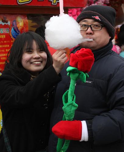 2月14日,一对情侣在北京朝阳公园逛庙会。 当日是农历正月初一,又是西方情人节,北京朝阳公园特别打造了一个以浪漫为主题的庙会——朝阳国际风情节,来自希腊、俄罗斯、法国、新西兰等国家的艺术家在庙会现场献艺。 新华社发(赵琬微 摄)
