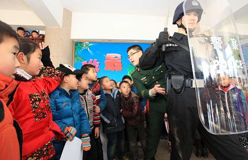1月10日,山东省即墨市公安局民警在即墨市第三实验小学向学生们展示出警中的基本技能。新华社发(梁孝鹏 摄)