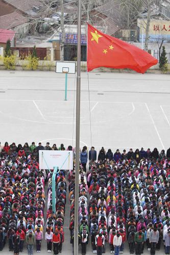 4月21日,山东省烟台市芝罘区凤凰台小学降半旗,1500多名师生为玉树地震遇难同胞默哀。 新华社发(申吉忠 摄)