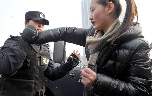 1月10日,合肥市公安局特警支队翟秀玲(左)在向市民介绍基本防身术。当日是全国“110宣传日”,安徽省合肥市公安局的特警们走上街头,向市民展示警犬、装备等,并和现场市民互动。新华社记者 郭晨 摄