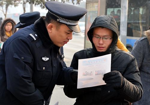 1月10日,一位民警在向市民介绍“110”功能。新华社记者 朱峥 摄