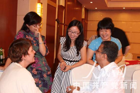 在采访间隙，中外记者热烈交谈。(人民网记者 李晓明摄)