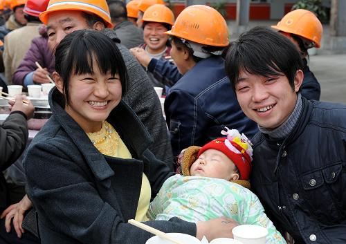 2月14日,这位叫叶冬(右)的小伙子第二次看到了自己出生4个月的儿子,他的妻子张莉(左)带着孩子从家乡来到汉旺镇,看望春节期间依然坚守在援建施工第一线的丈夫。 当日,江苏无锡援建指挥部和绵竹市汉旺镇一起为无锡援建者们摆下“坝坝宴”,庆祝农历虎年的第一天。绵竹市领导和当地乡亲为他们送上了腊肉、香肠和美酒,村民们还为援建者献上了感谢的锦旗。 新华社记者 陈燮 摄