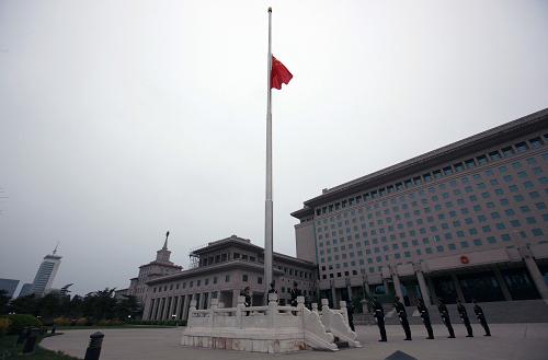 4月21日,北京解放军八一大楼前国旗升起后,缓缓降下半旗向玉树地震遇难同胞志哀。新华社记者王建民摄