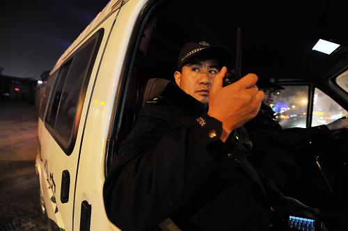 1月9日,110民警周建宝通过对讲机接听中心发布的警情。新华社记者 彭昭之 摄