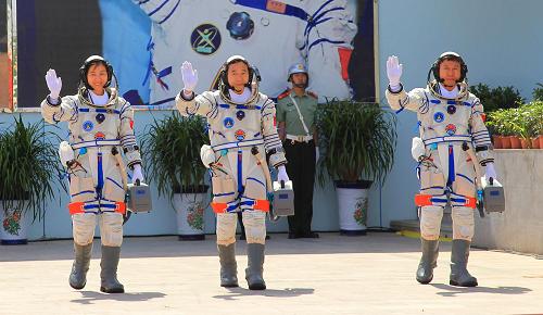 6月16日,神舟九号航天员出征仪式在酒泉卫星发射中心航天员公寓问天阁举行。这是景海鹏、刘旺、刘洋走出问天阁南门,来到圆梦园广场。新华社记者 李刚 摄