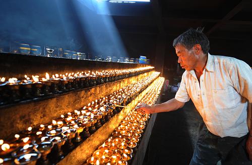 4月21日,一名拉萨市民在大昭寺前供千盏灯,哀悼玉树地震遇难同胞。 新华社记者 觉果摄