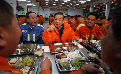 这是1月1日,温家宝在青岛港老港区职工餐厅和节日值守的职工们共进晚餐。新华社记者 姚大伟 摄