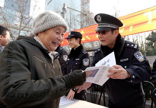 1月10日,民警在向一位老人发放宣传资料 。当日是一年一度的“110宣传日”,上海市静安公安分局在辖区内举行“亲民、爱民、为民”主题活动 ,出黑板报、放宣传片、介绍110报警常识、请市民体验警用装备、指导群众防范电讯诈骗。新华社记者 凡军 摄