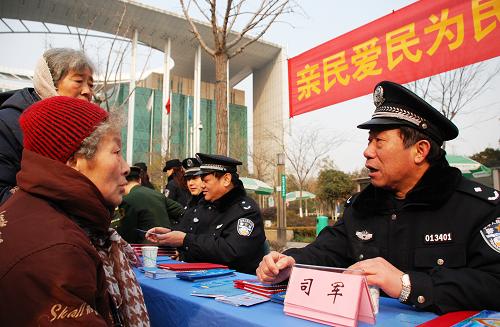 1月10日,一位警察在“110宣传日”广场活动中为市民答疑。当日是全国“110宣传日”,江苏南京警方组织110指挥中心、治安、刑侦、交管、消防等警种在南京图书馆中心广场,举行以“亲民、爱民、为民,110在你身边”为主题的110宣传日活动,吸引许多群众参与。据南京市公安局新闻发言人介绍,2012年南京警方接警总量突破400万件,接警短信回访满意率96.96%。新华社发(李响 摄)