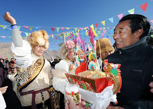 2月14日,拉萨西郊安居院藏族群众互相敬献“切玛”。当日是藏历铁虎新年第一天,拉萨市民沉浸在新年的欢乐之中,人们身着盛装载歌载舞,互敬象征五谷丰登的“切玛”和青稞美酒,互祝藏历新年“扎西德勒”。 新华社记者 觉果摄
